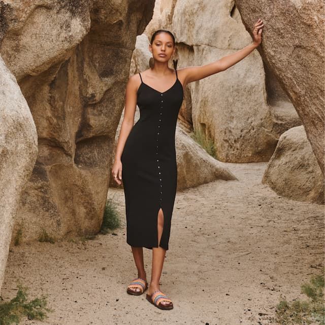 A model wears a black midi v-neck dress.