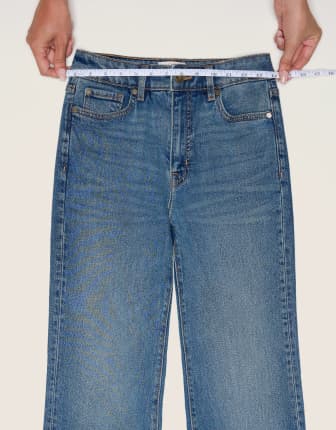 Place the measuring tape on the waistband of a pair of jeans.