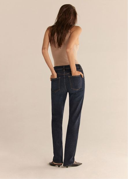 A model wears the Chiara slim-straight jeans in dark blue with a beige tank top.