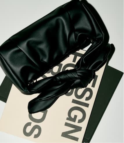 Faux leather black handbag on table.