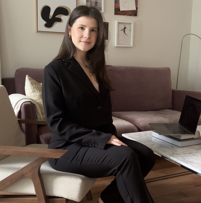 An influencer wears a black blazer and black pants.