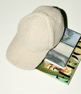 Faux shearling hat on books.