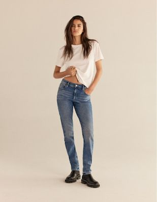 Une mannequin porte le jean ajusté Liya en bleu moyen avec un t-shirt blanc.