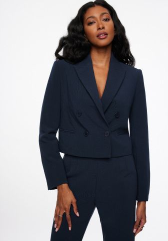 Model is wearing a navy blazer and navy pants.