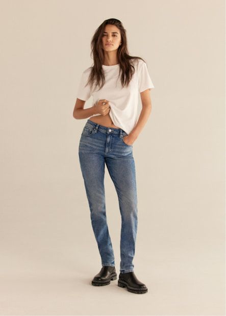 Une mannequin porte le jean ajusté Liya en bleu moyen avec un t-shirt blanc.