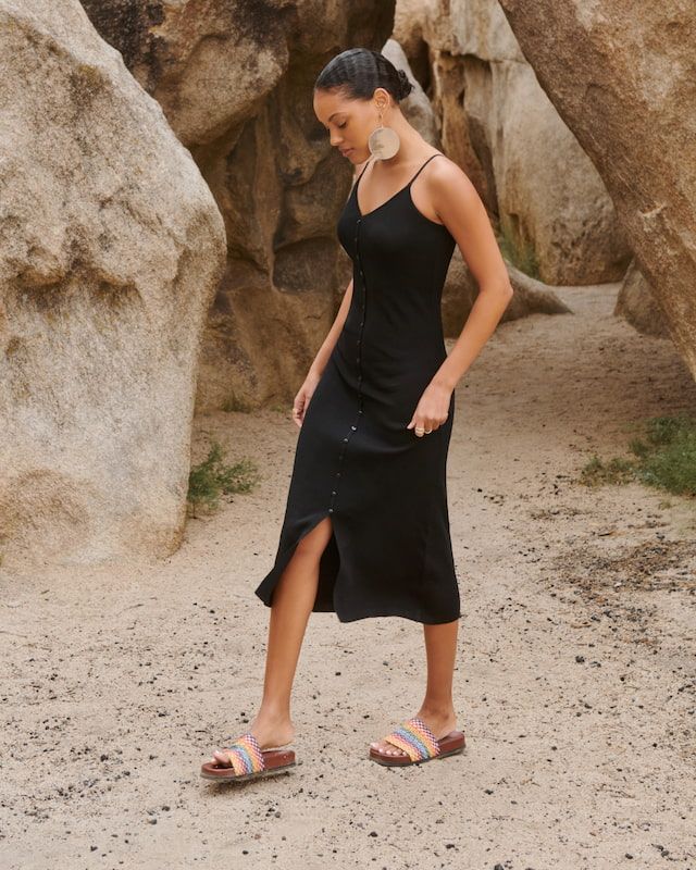 A model wears a black midi v-neck dress.