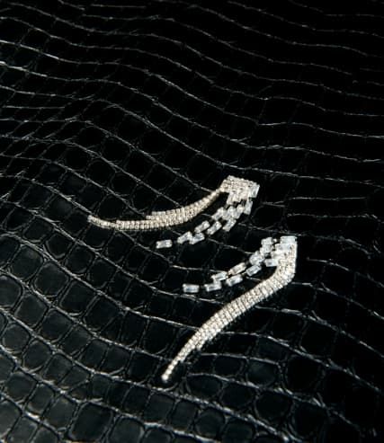 Silver baguette earrings on croco print background.