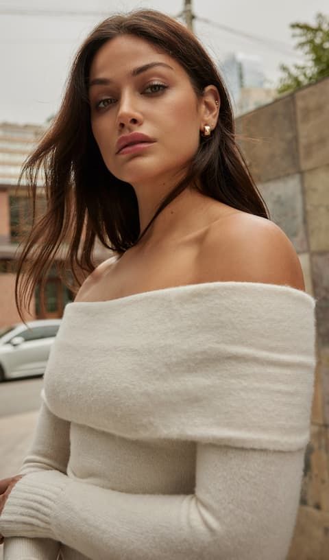 Model wears white off-shoulder sweater.