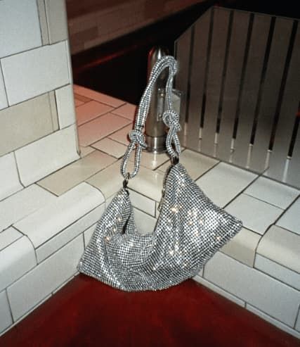 Silver gemmed knotted handbag.