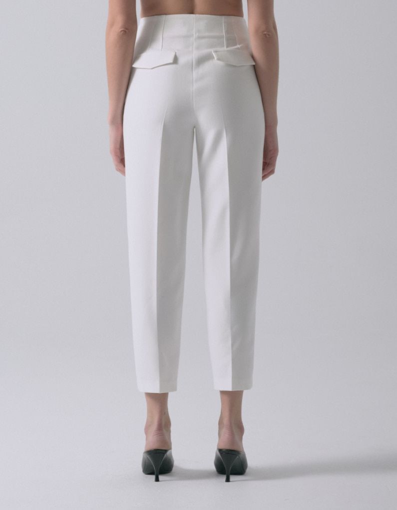 Une mannequin porte un pantalon blanc à jambe ajustée - vue arrière.