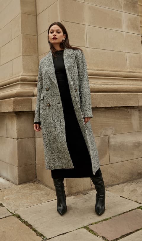 Model wears grey tweed top coat with black dress.