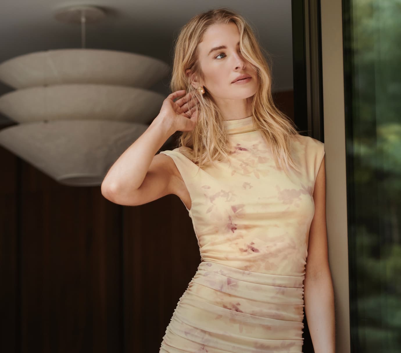 Model is wearing a yellow floral mini dress.