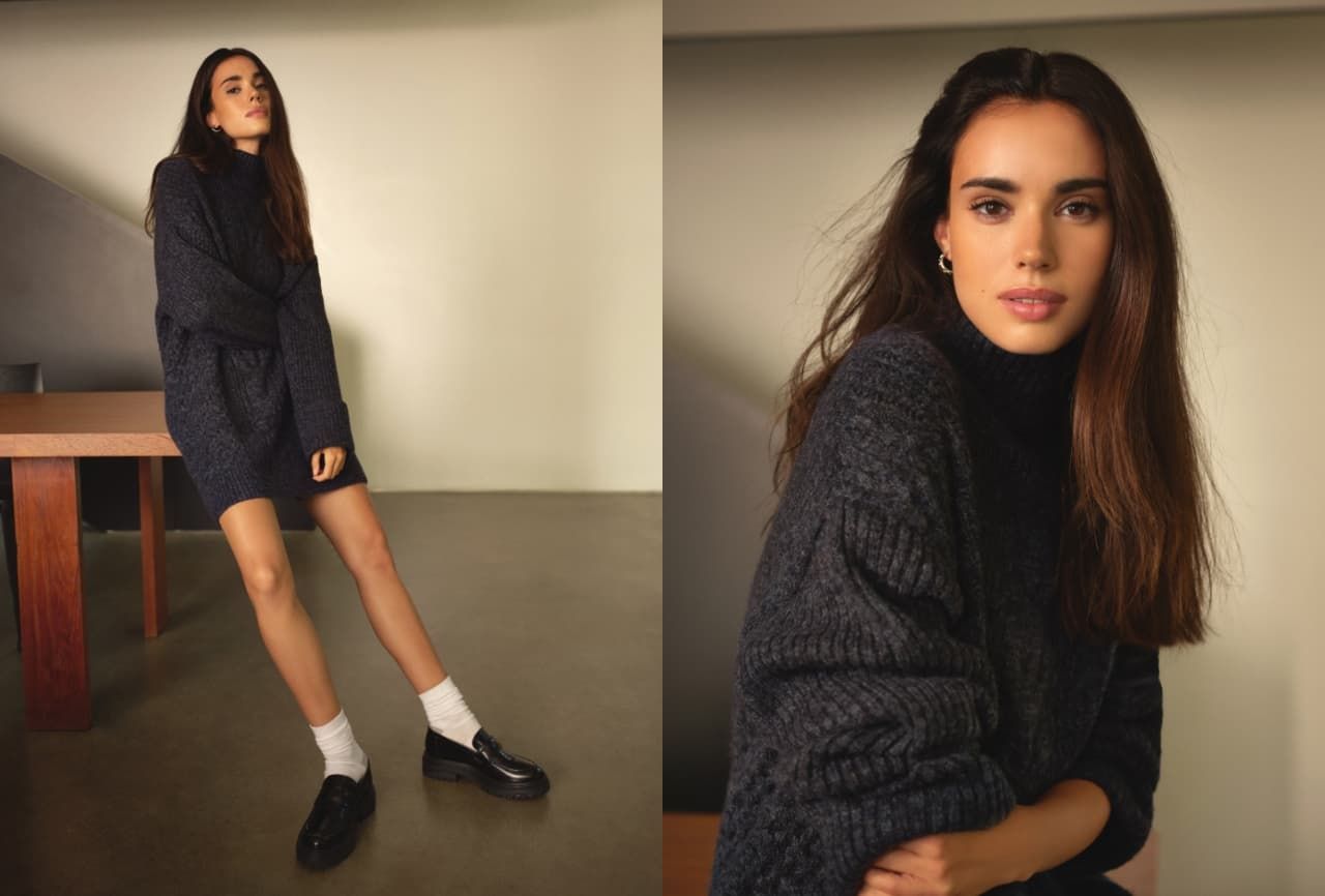 A model wears a dark grey knit mockneck sweater dress.