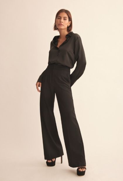 A model wears black straight leg pants with a black blazer.