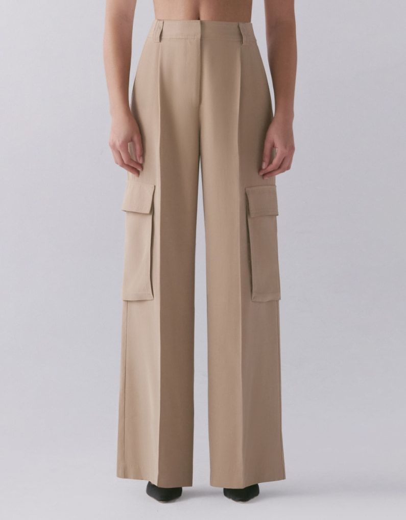 Une mannequin porte un pantalon cargo beige à jambe large.