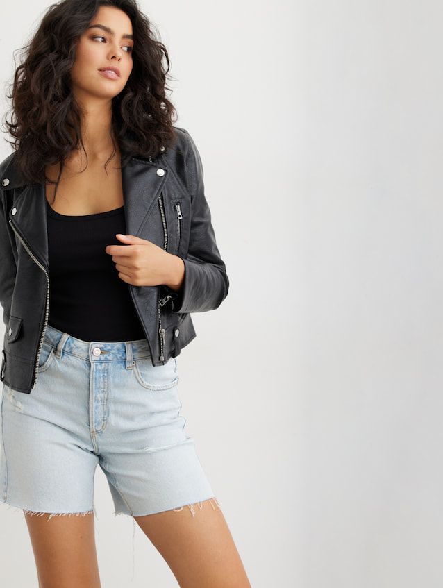A model wears black scoop-neck tank with a black leather jacket and denim shorts.