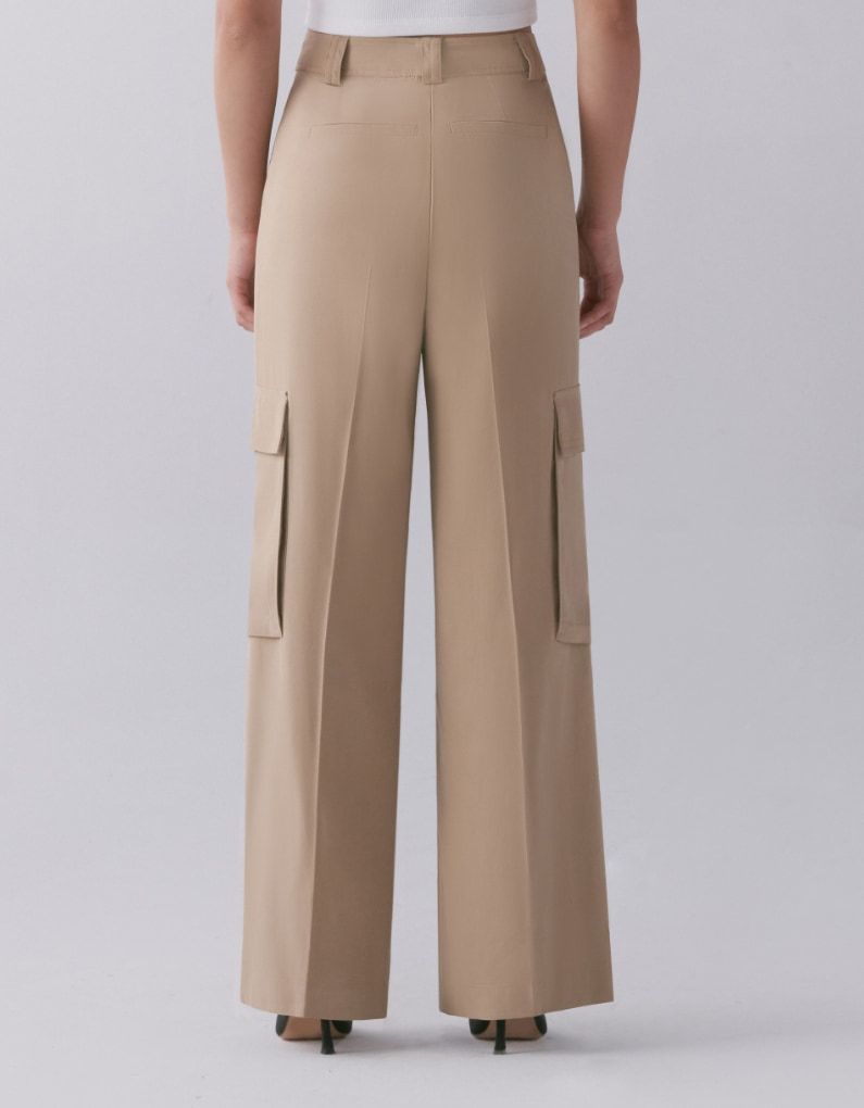 A model wears beige wide leg cargo pants - back view.