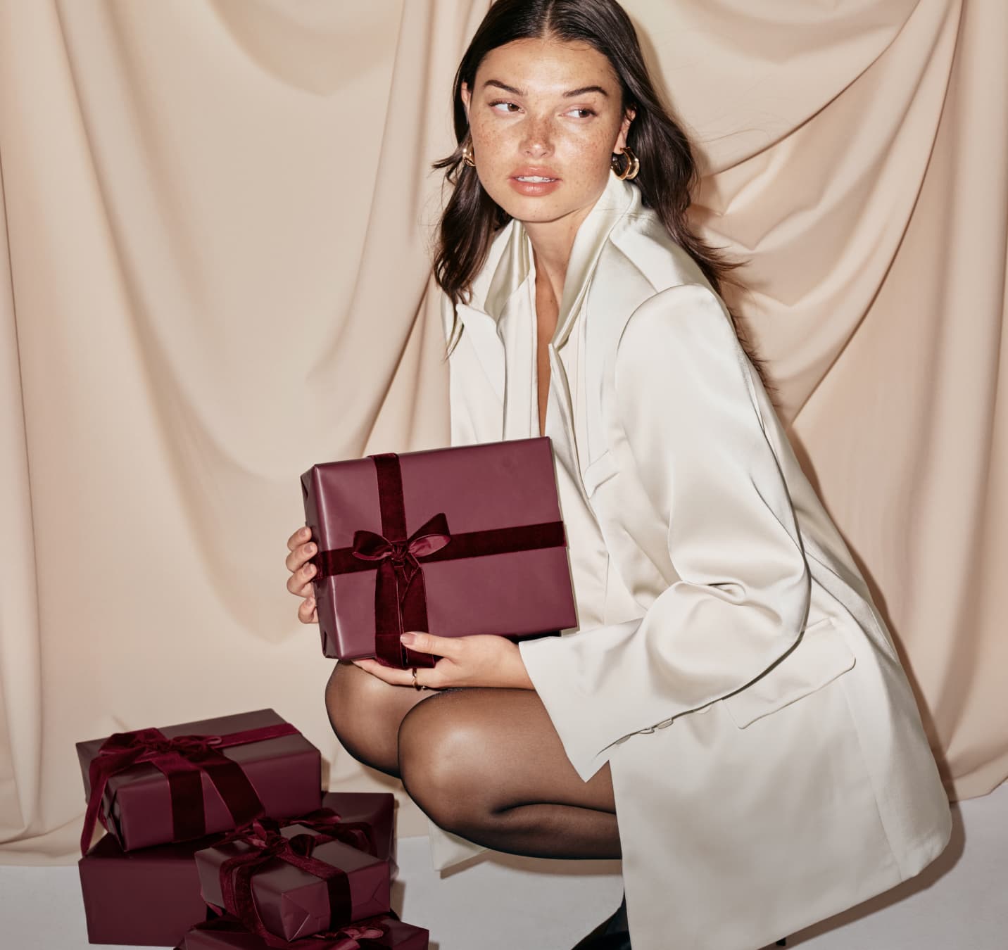 Model is wearing a white satin blazer.