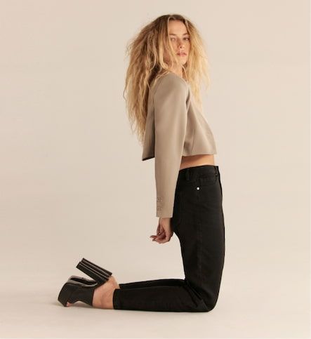 A model wears the Claudia mom jeans in black with a cropped beige blazer.