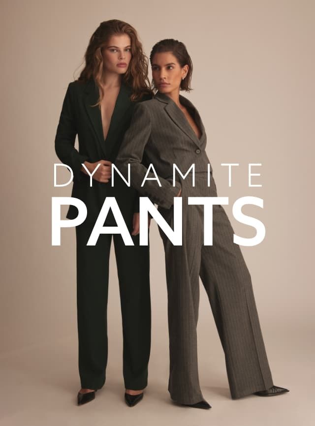 One model wears a forest green blazer and matching pants and the other model wears a grey pinstriped cropped blazer with matching pants.
