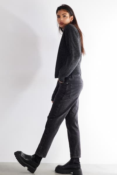 A model wears a black long sleeve shirt with black mom jeans.