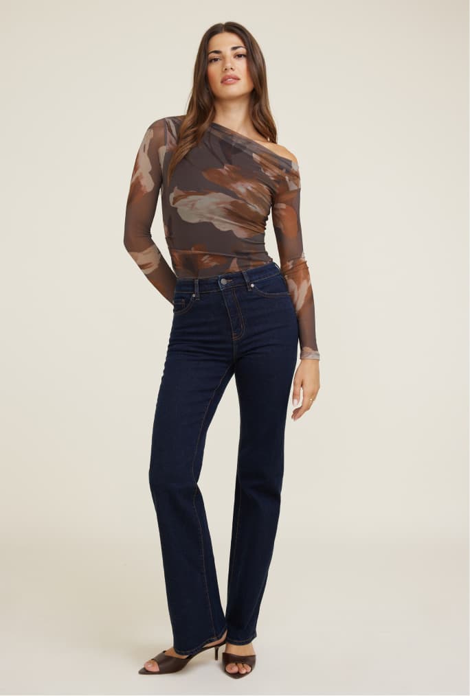Model is wearing a brown floral off shoulder top with black jeans.