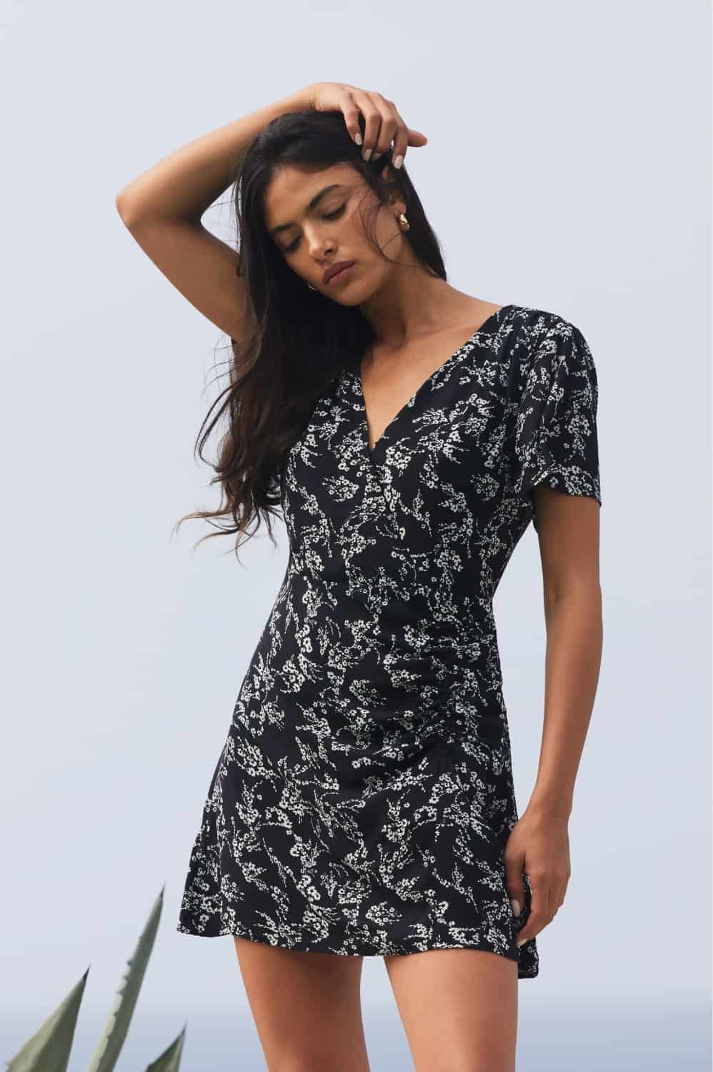 A model wears a printed black and white short sleeve wrap dress.