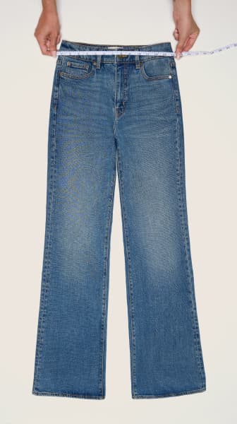 Place the measuring tape on the waistband of a pair of jeans.