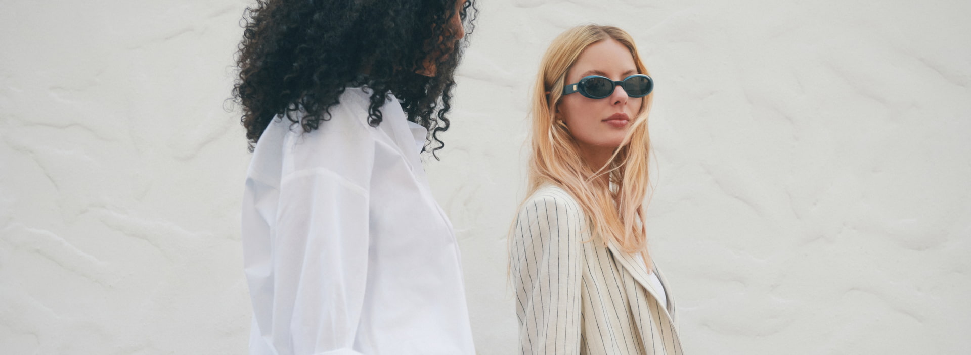 A model wears a white blazer romper and another wears a blazer.