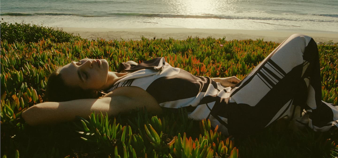 Model is wearing a brown and white printed top and skirt set.
