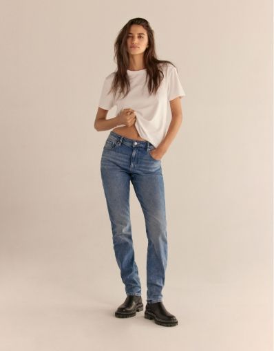 A model wears blue slim jeans with a white t-shirt.