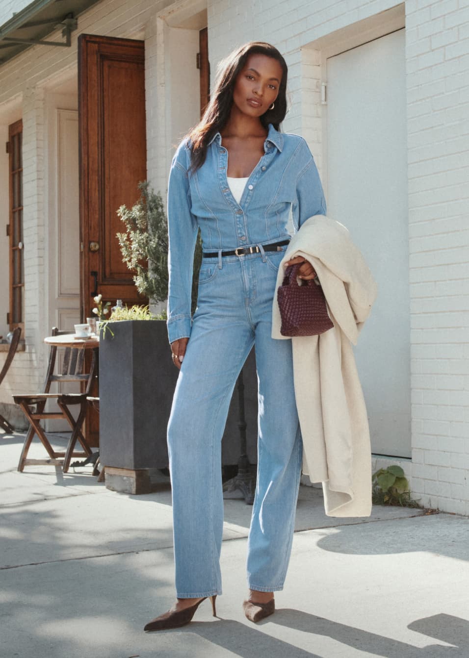 Model is wearing a light wash denim shirt with light wash jeans.
