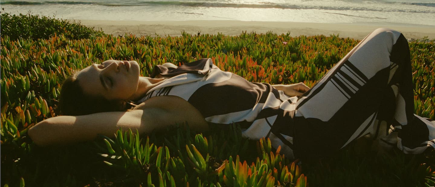 Model is wearing a brown and white printed top and skirt set.