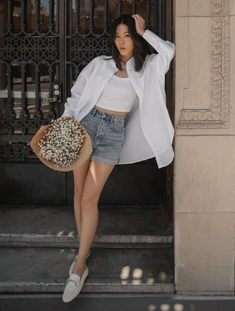  Model is wearing denim shorts and a white shirt.