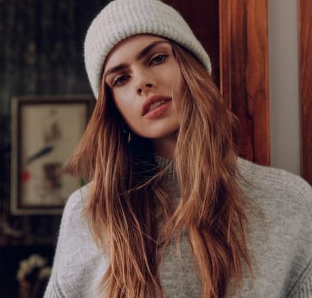 Model is wearing a matching grey beanie and sweater.