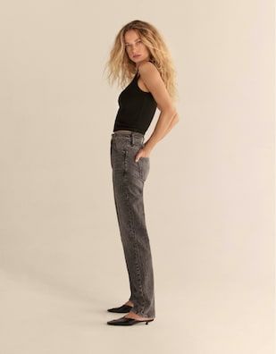 A model wears the Chiara slim-straight jeans in dark grey with a black tank top.