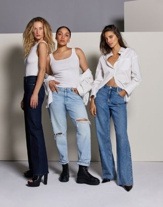Three models wear straight leg, boyfriend and wide leg blue jeans with white tops 