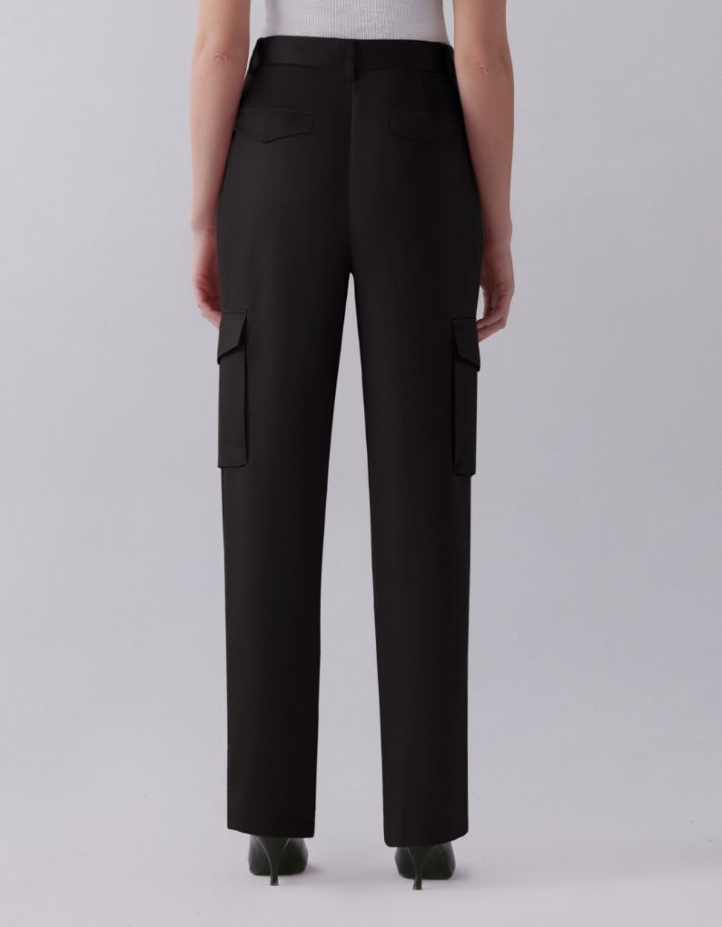 A model wears black satin straight leg pants - back view.